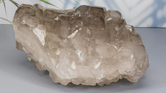 Crystal quartz rock on a gray surface with a blurred background