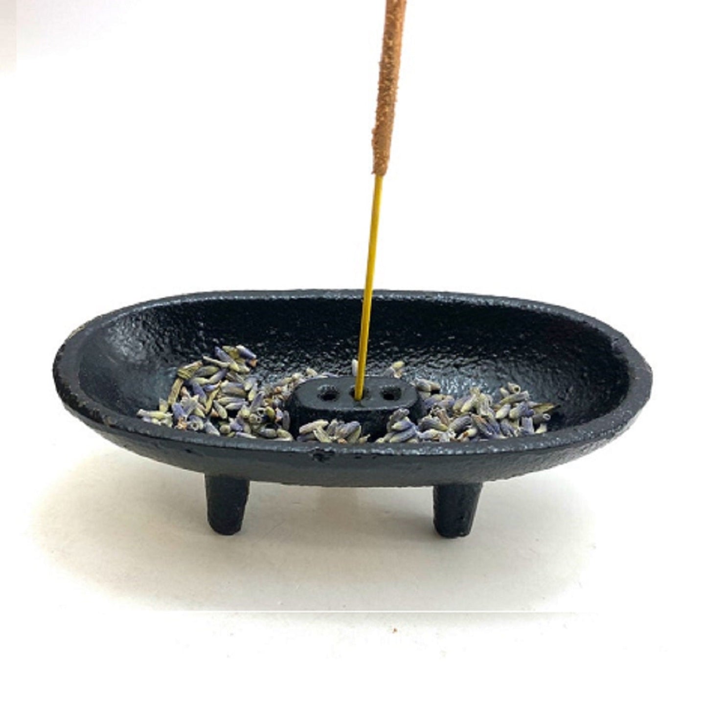 Black incense burner with incense sticks on a white background