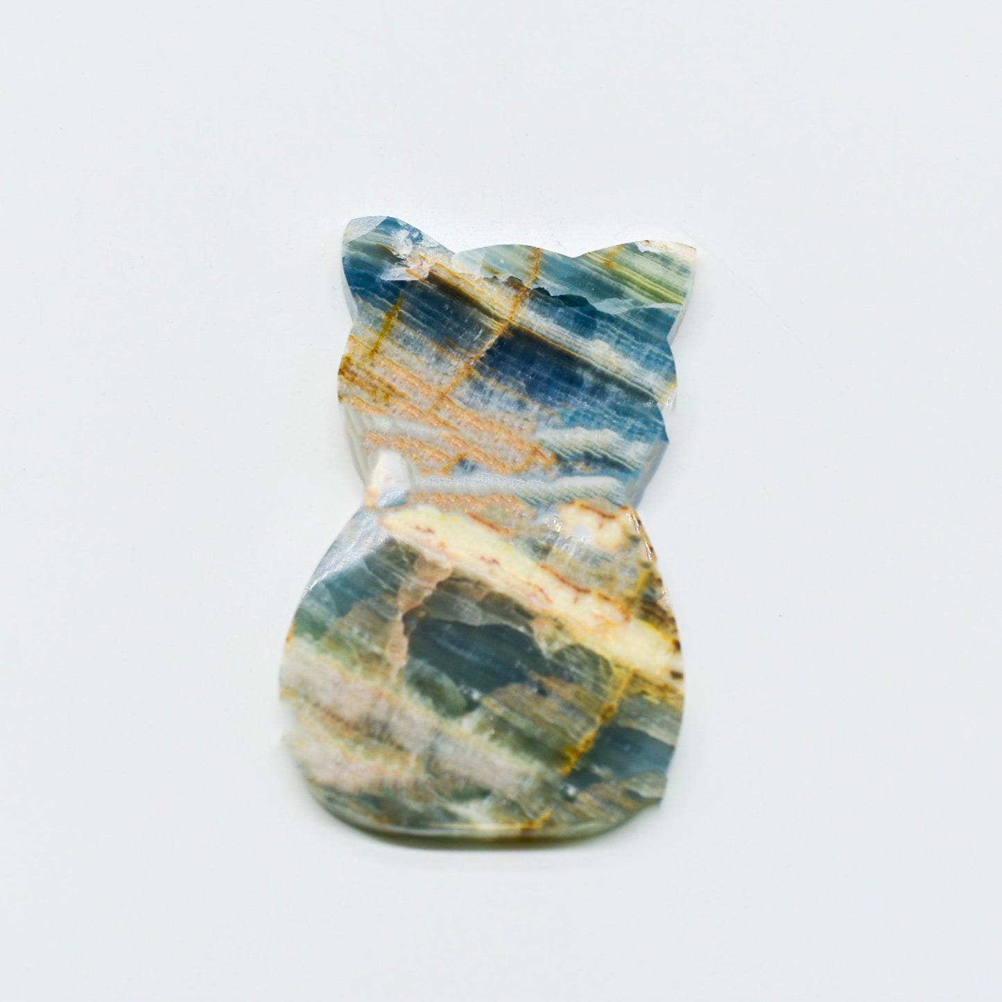 Polished blue onyx with blue, green, and gold patterns on a white background