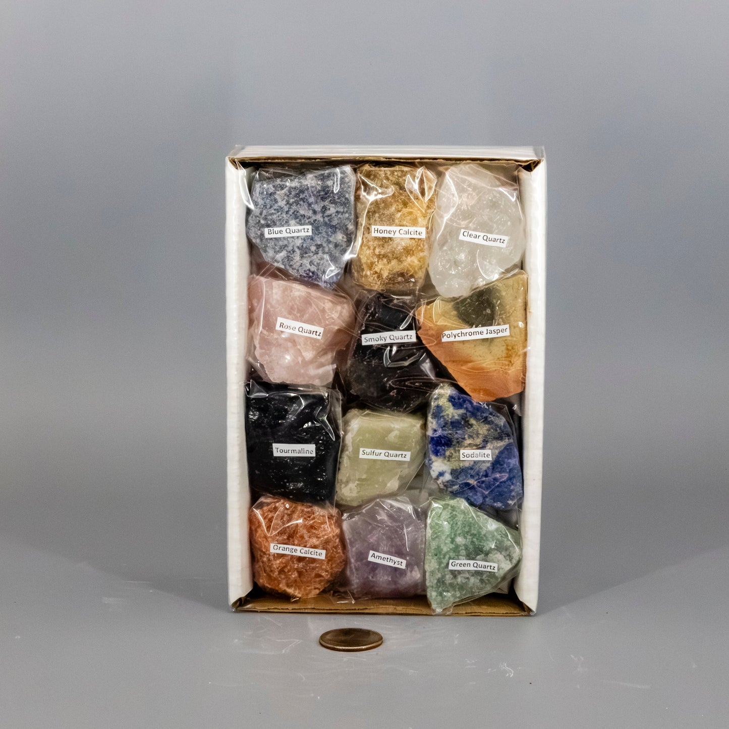 Box of various colored stones with labels on a gray background