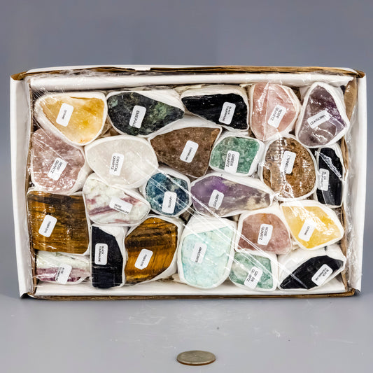 Box of various colored stones with labels on a gray background