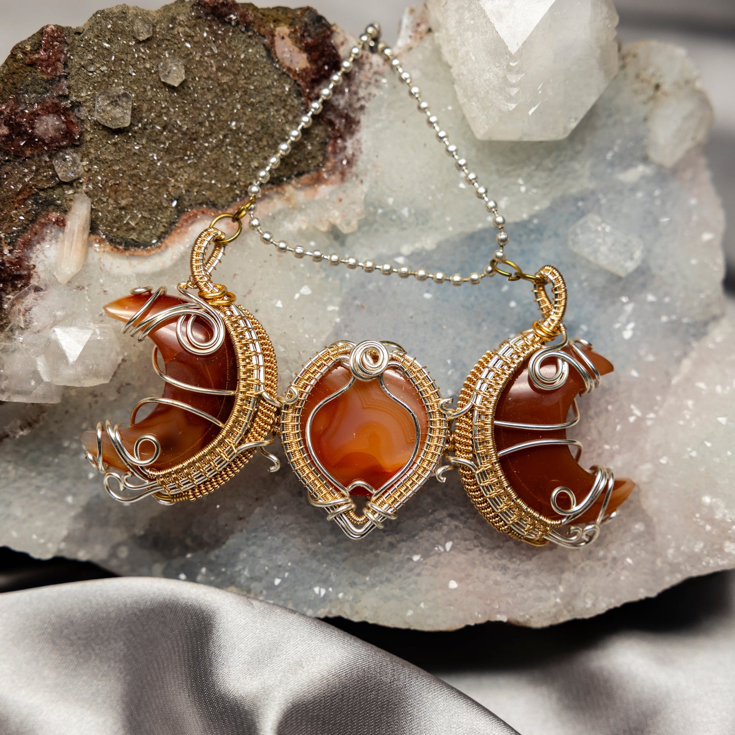 Ornate necklace with orange carnelian agate stones on a crystal background