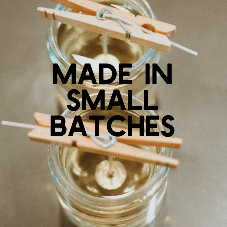 Glass jar with clothespins and text 'MADE IN SMALL BATCHES' on a neutral background