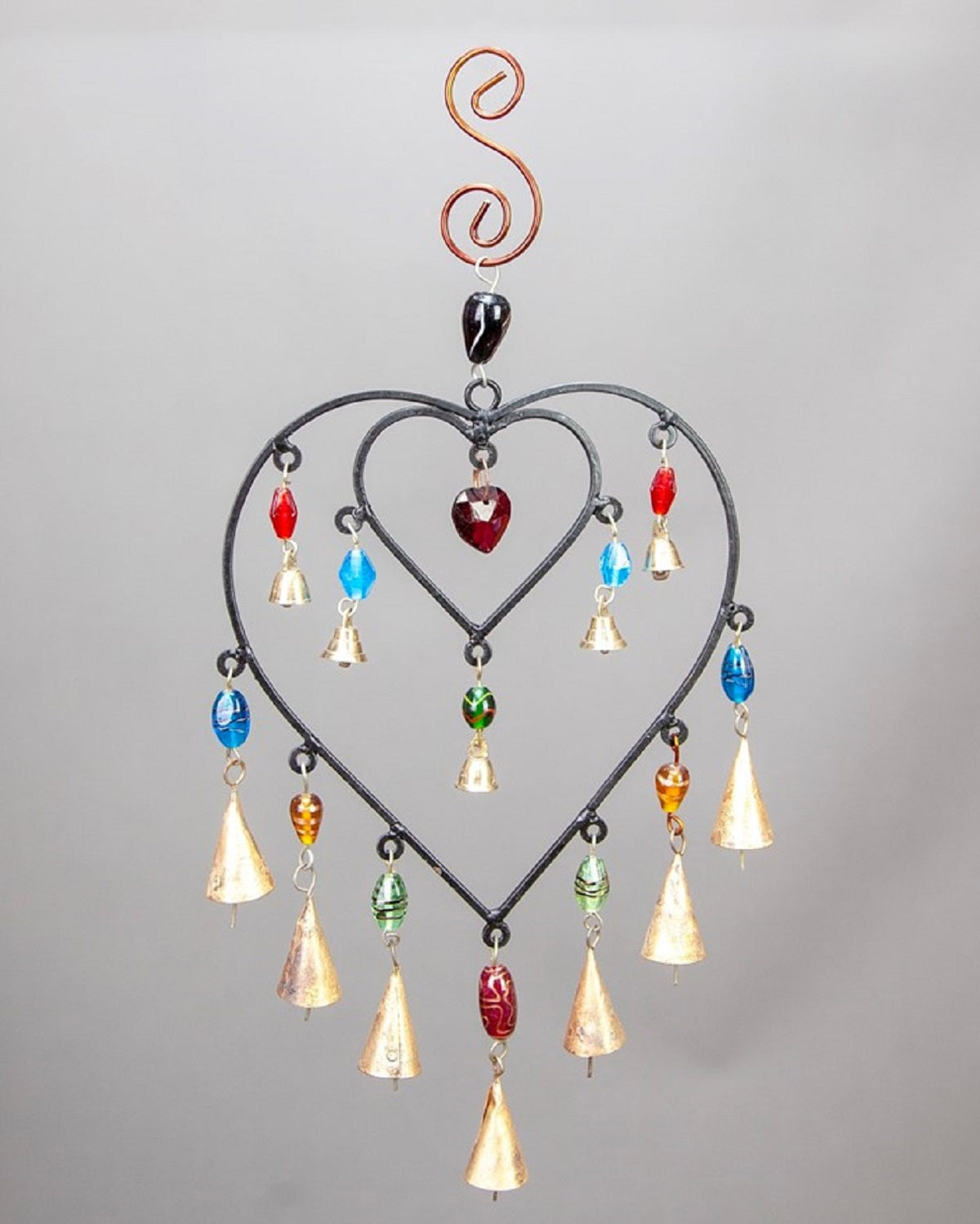 Decorative hanging heart-shaped ornament with colorful beads on a gray background