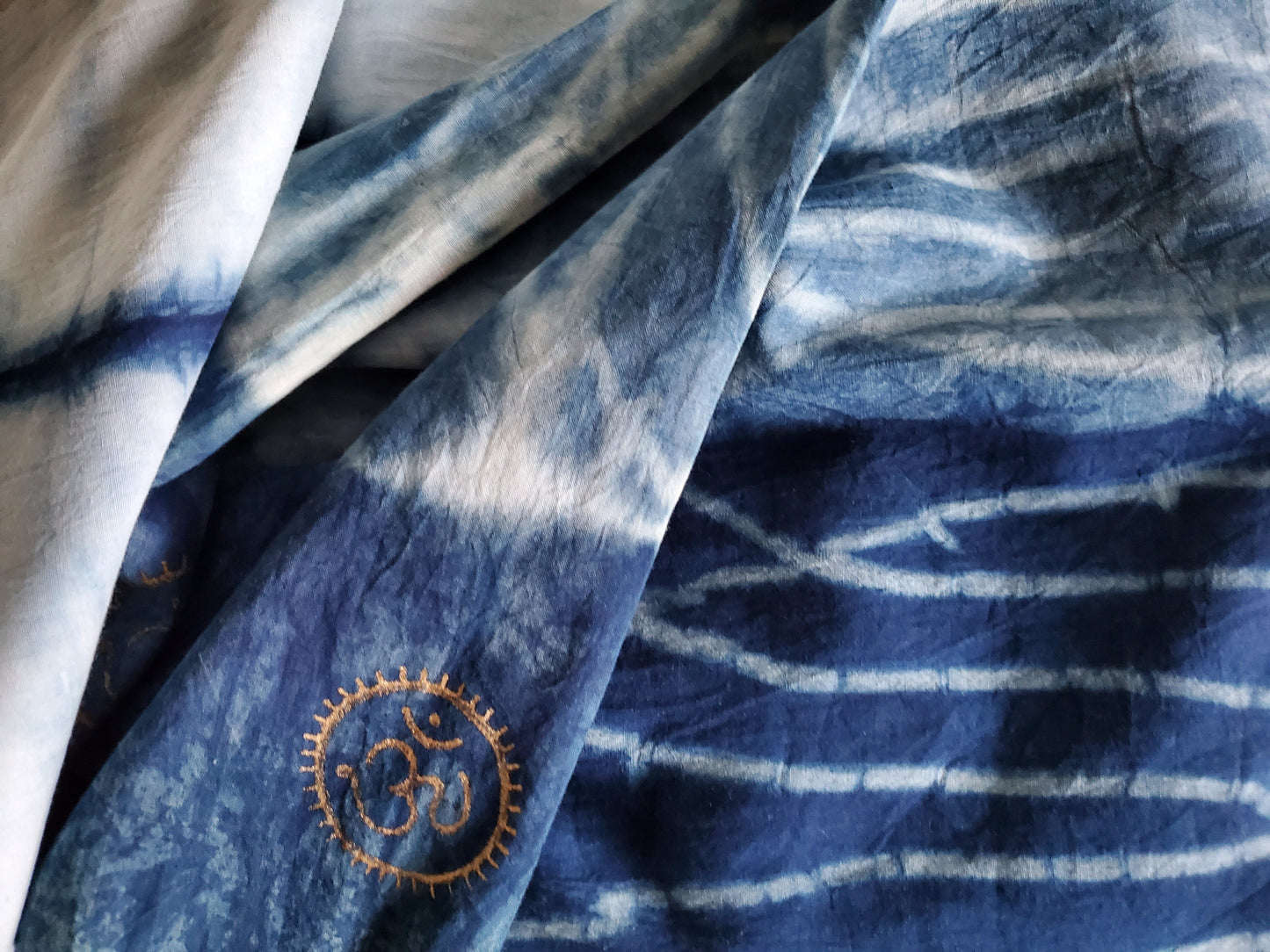 Close-up of blue and white patterned fabric with a embroidered symbol.