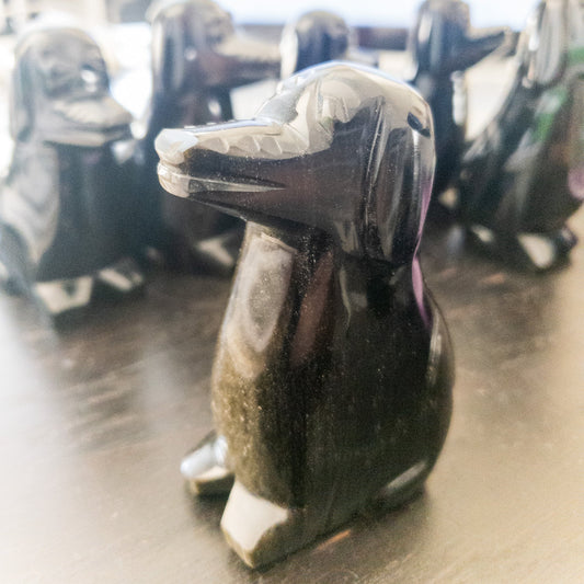 Black Obsidian dog figurine on a wooden surface with blurred background