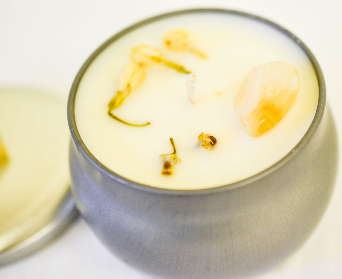 Candle in a glass holder with floral elements on a white background