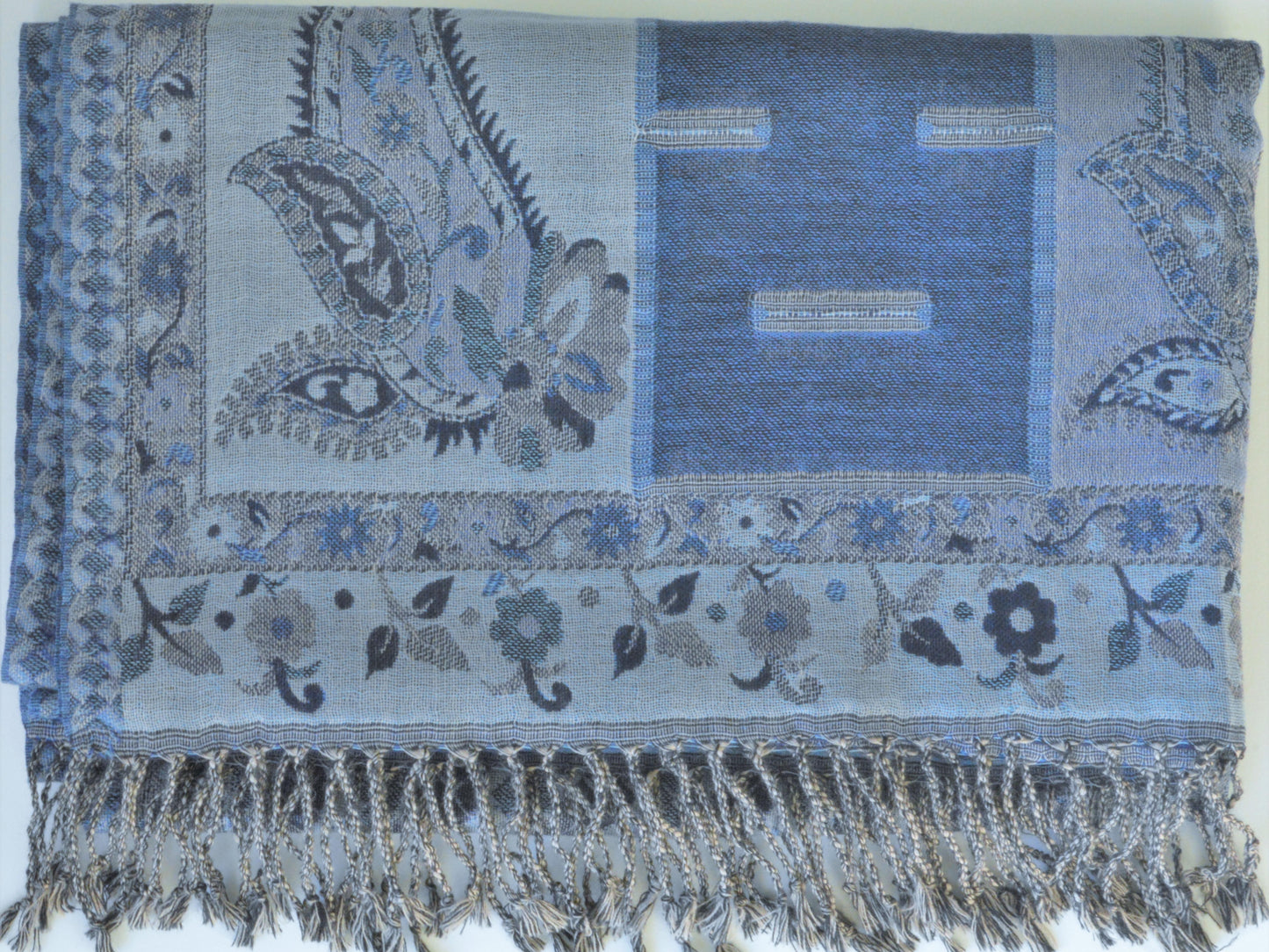 Blue patterned shawl with paisley designs and fringes on a white background