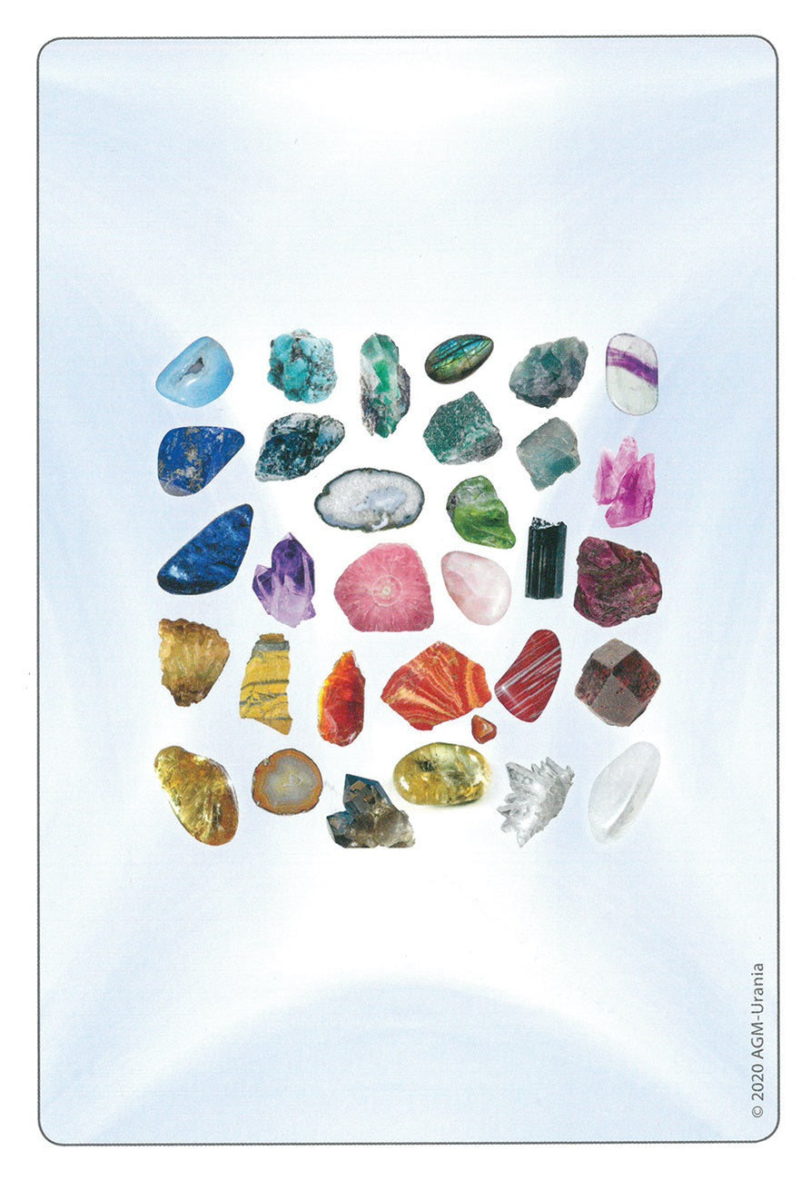 Collection of various colorful crystals arranged in a circular pattern on a light blue background.