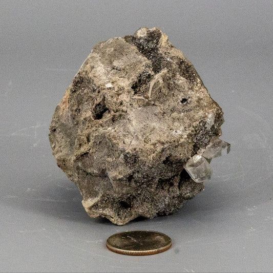 Mineral sample with herkimer diamond crystal formation on a gray background