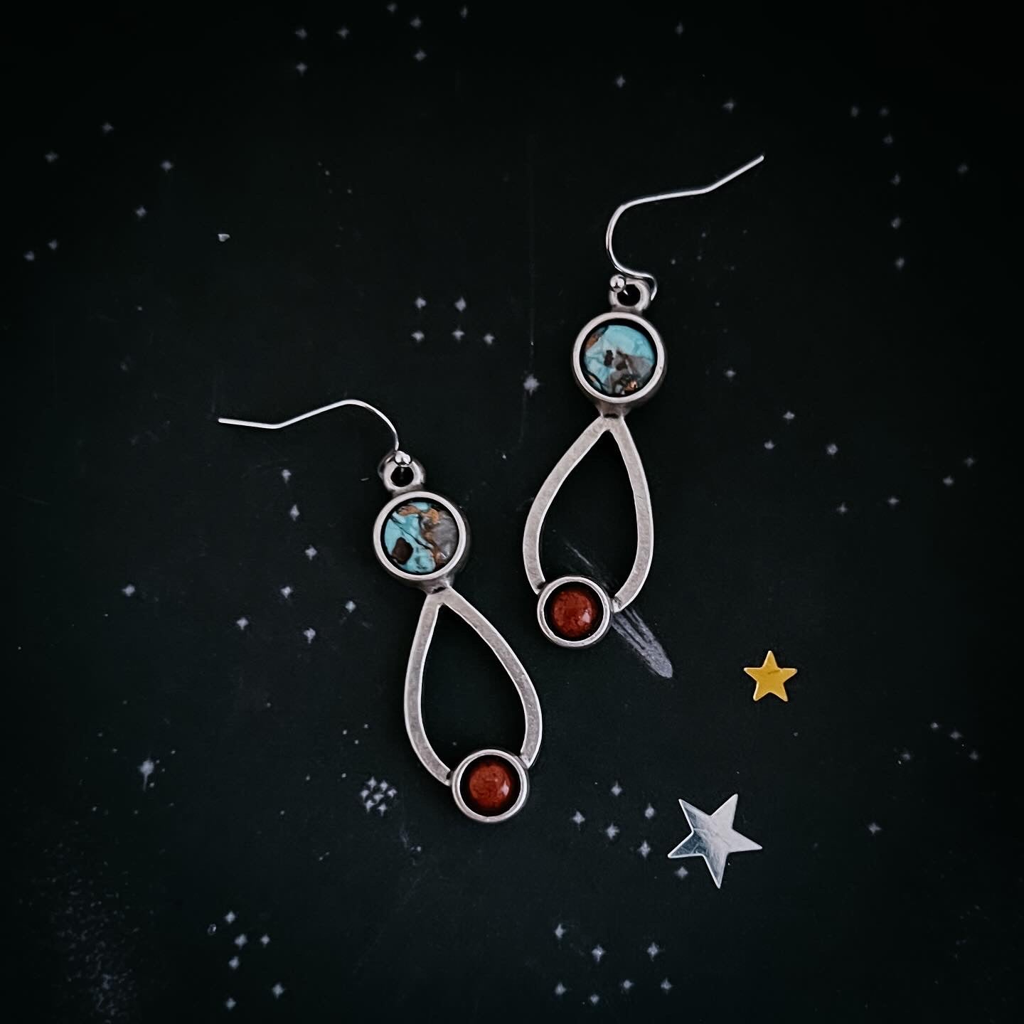 Silver earrings with gemstones on a starry night background