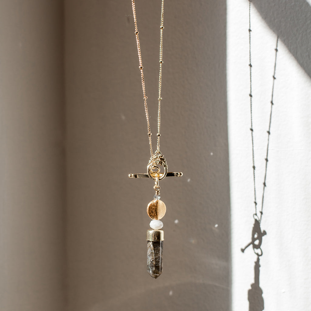 Labradorite lariat necklace with a pendant on a neutral background