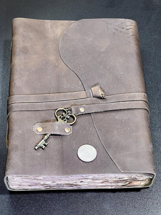 Leather-bound journal with a lock and key charm on a dark background