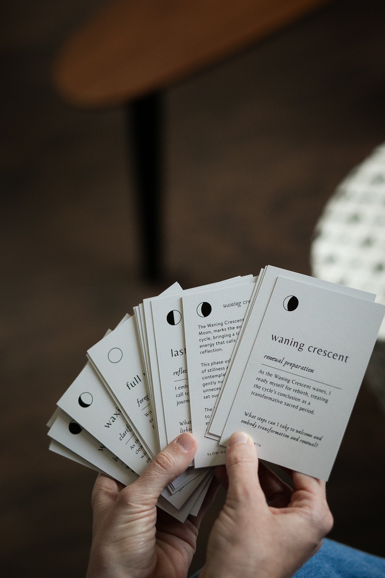 Hand holding a set of white cards with text against a blurred background
