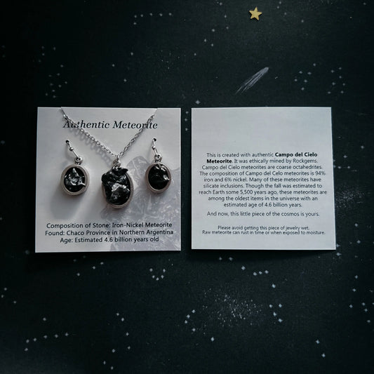 Meteorite jewelry set with authenticity cards on a dark background