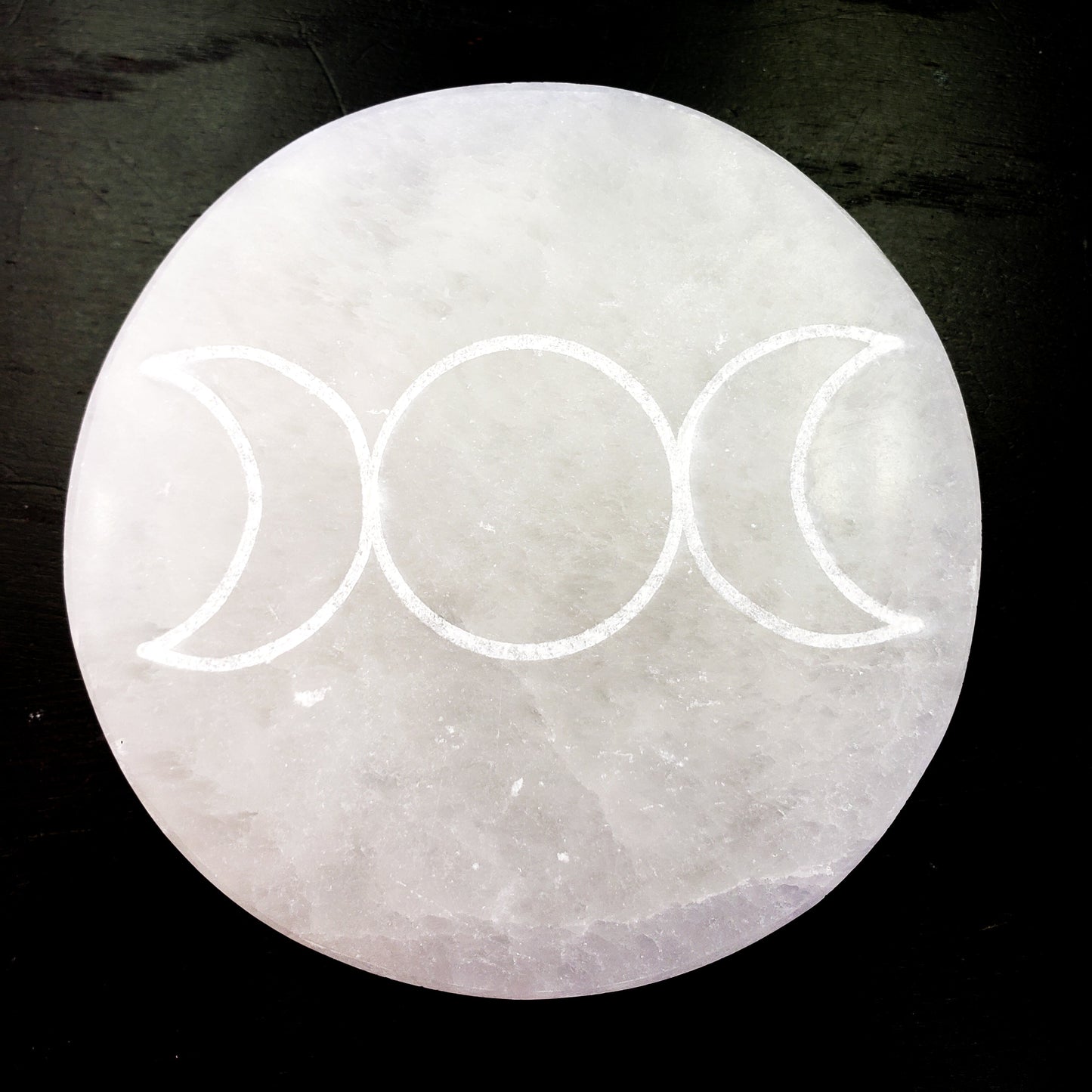 Crystal with triple moon symbol on a dark background