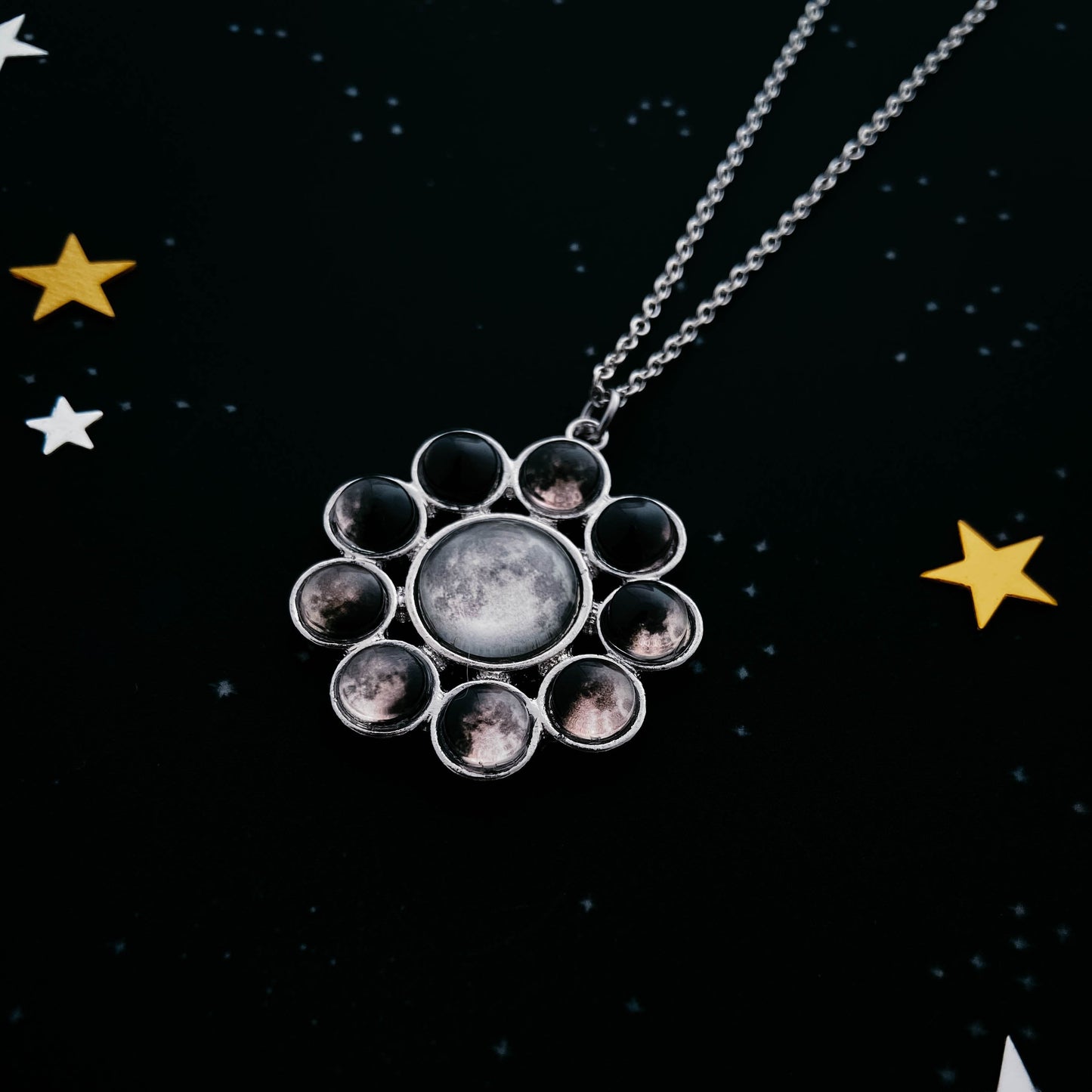 Necklace with a circular pendant featuring moon phases on a starry night background