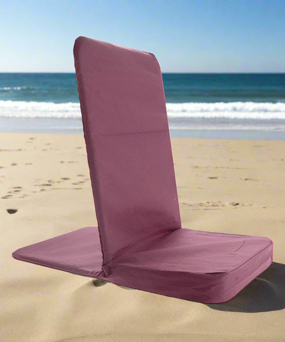 Purple meditation chair on a sandy beach with ocean waves in the background