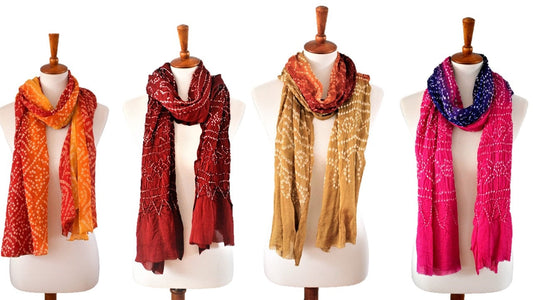 Four silk scarves in different colors on mannequins against a white background
