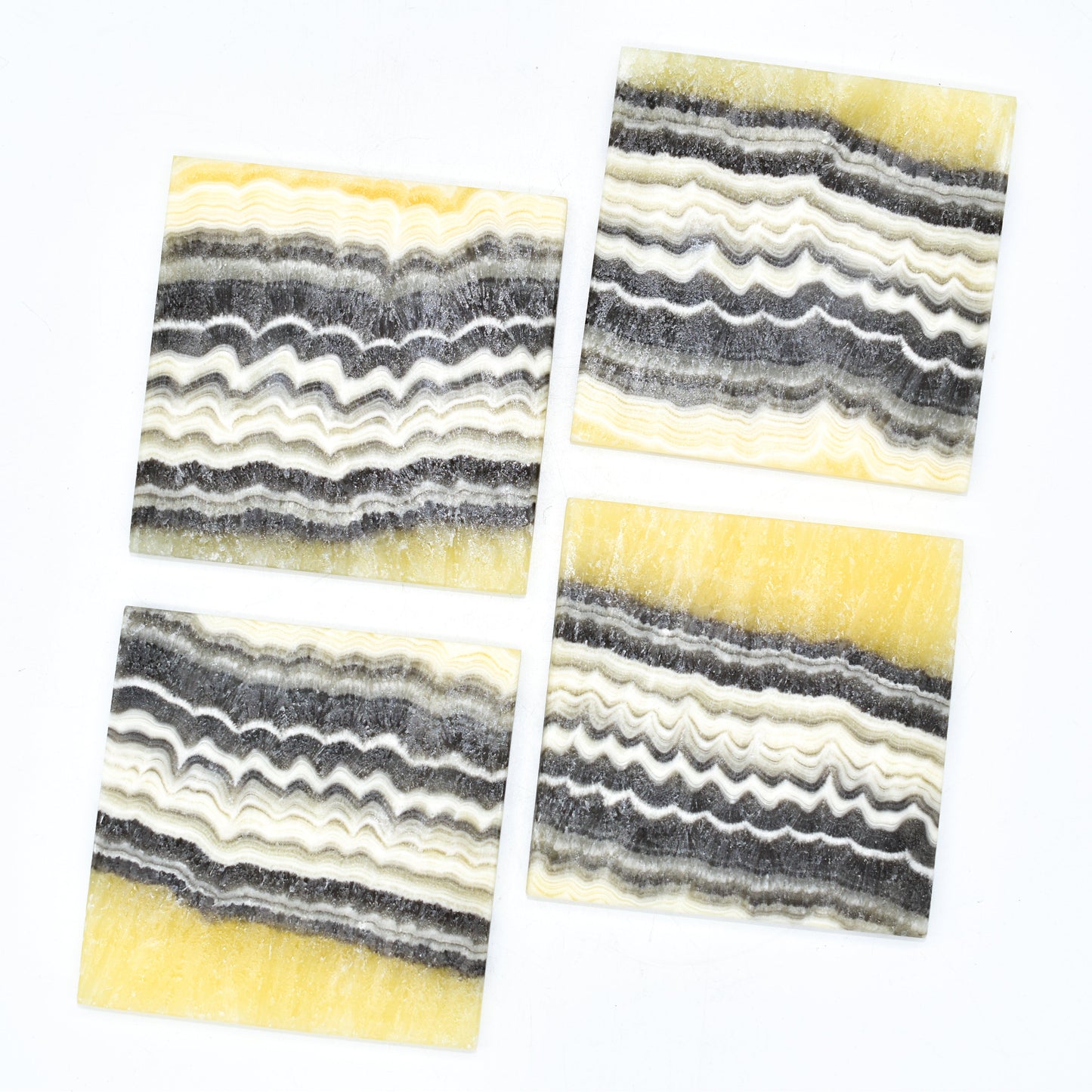 Four striped coasters with wavy pattern on a white background