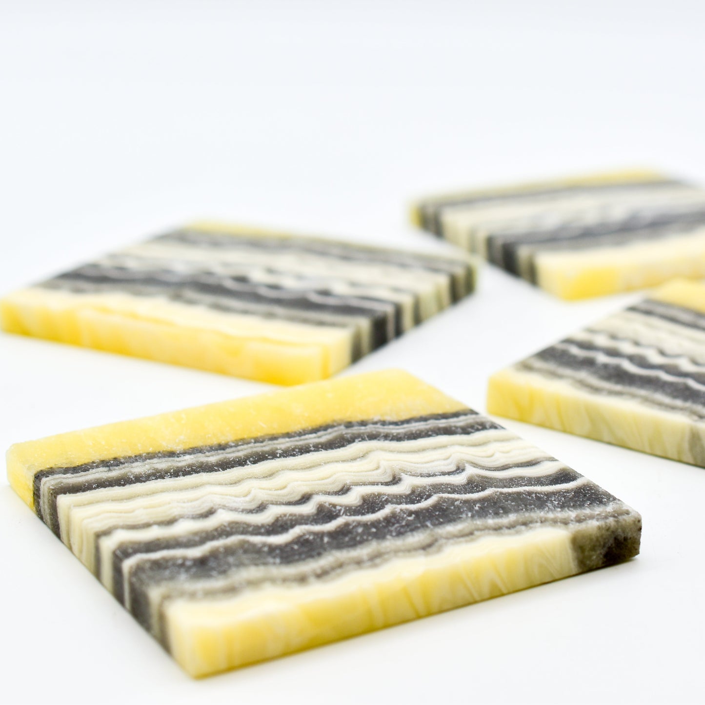 Marble-patterned coasters with yellow edges on a white background
