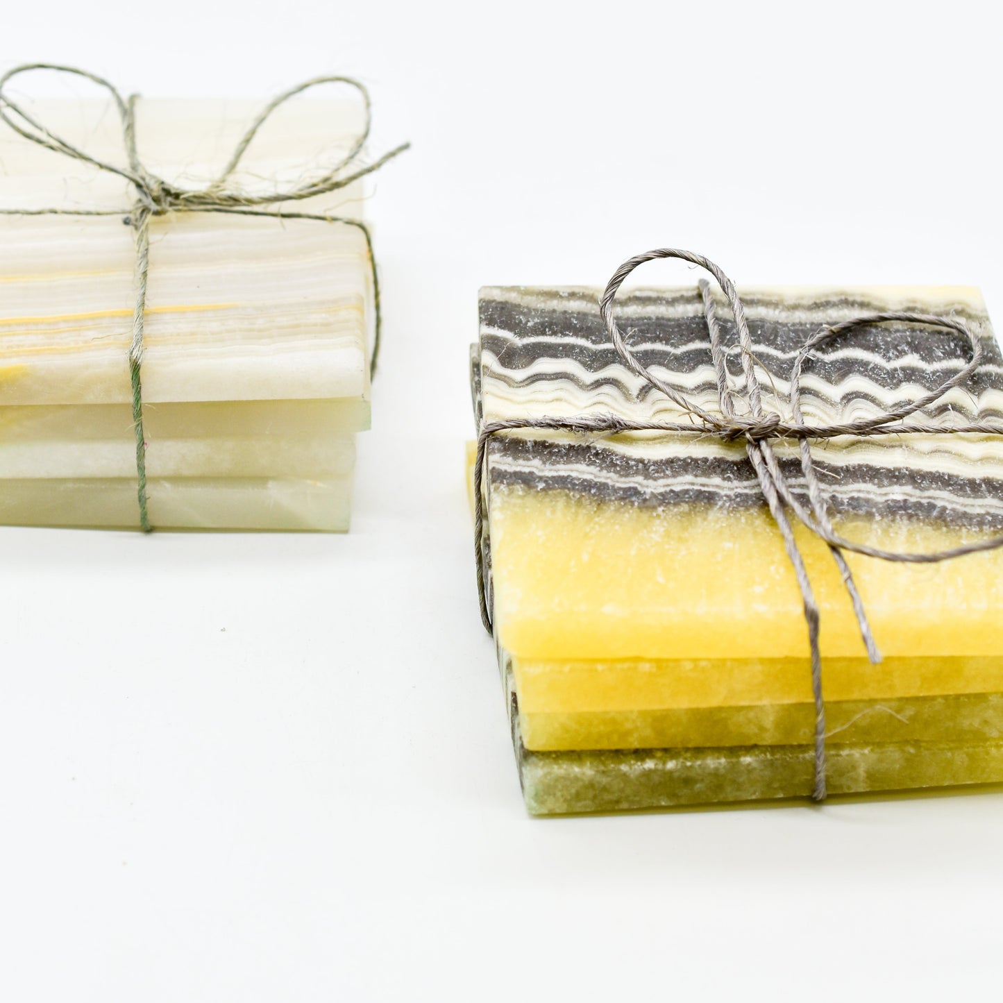 Two bundles of coasters tied with string on a white background
