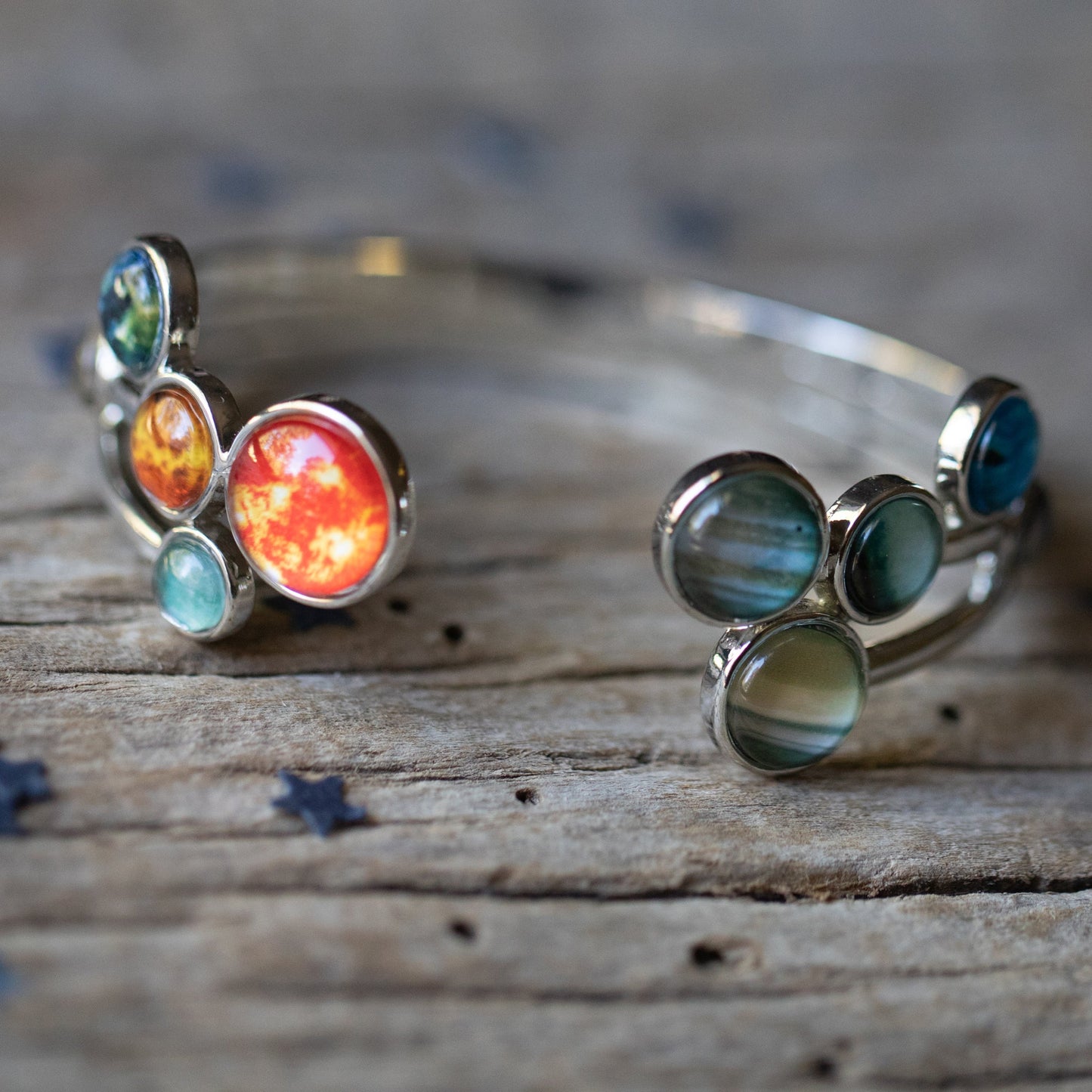 Silver bangle with colorful gemstones on a wooden surface