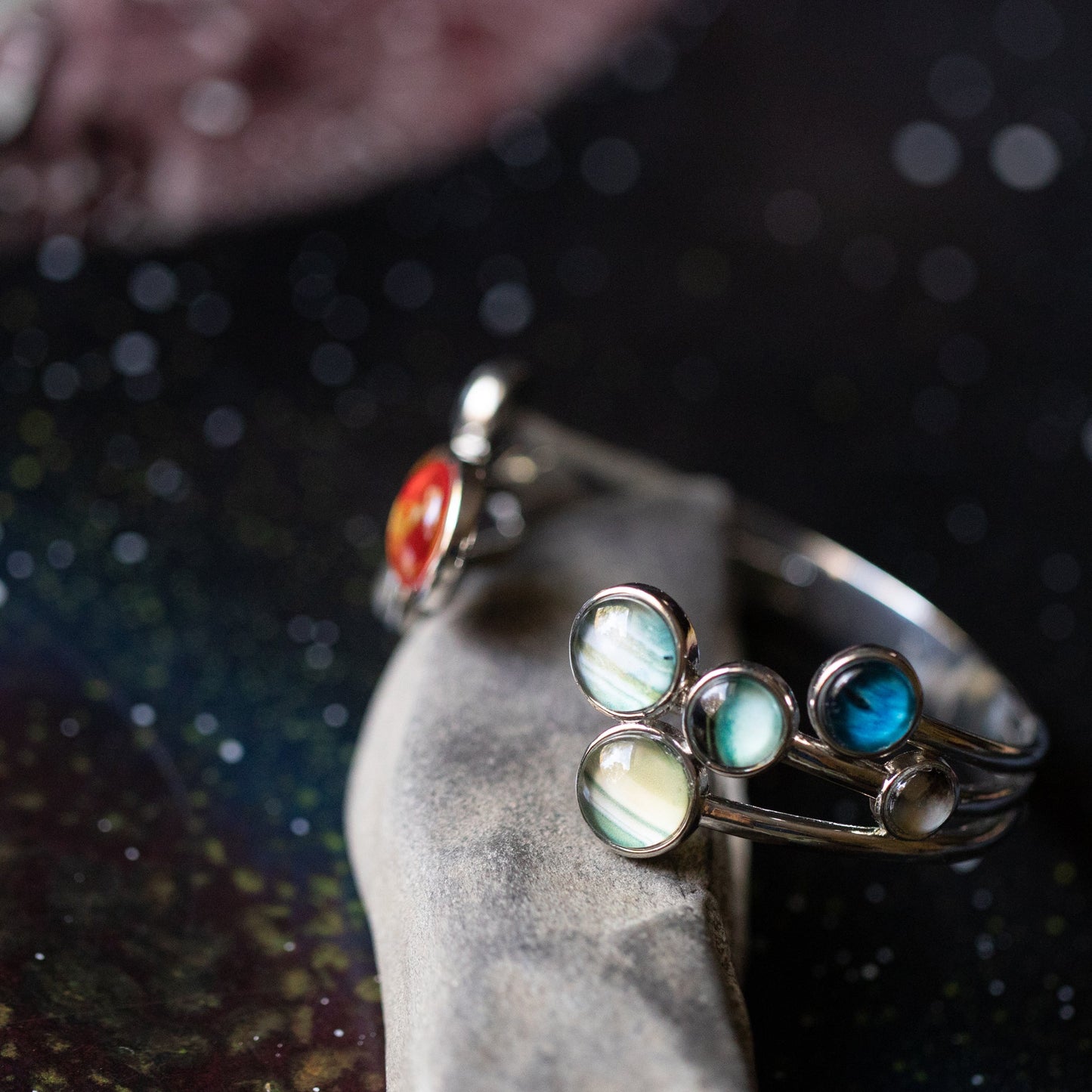 Silver bracelet with colorful gemstones on a dark textured background