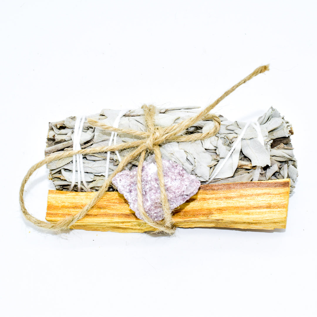 Bundled sage sticks with crystals on a white background