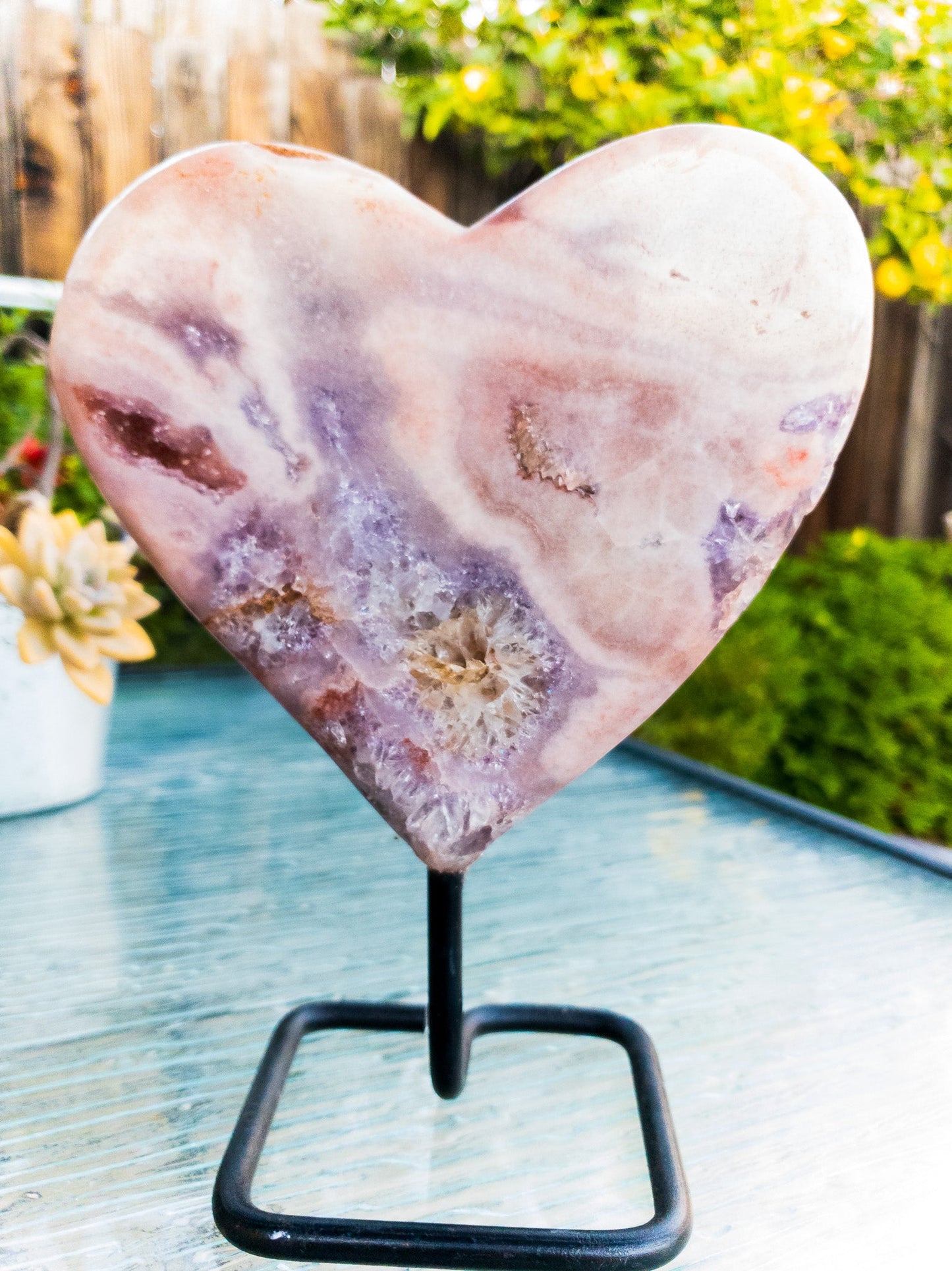 Heart-shaped stone on a stand with a garden background