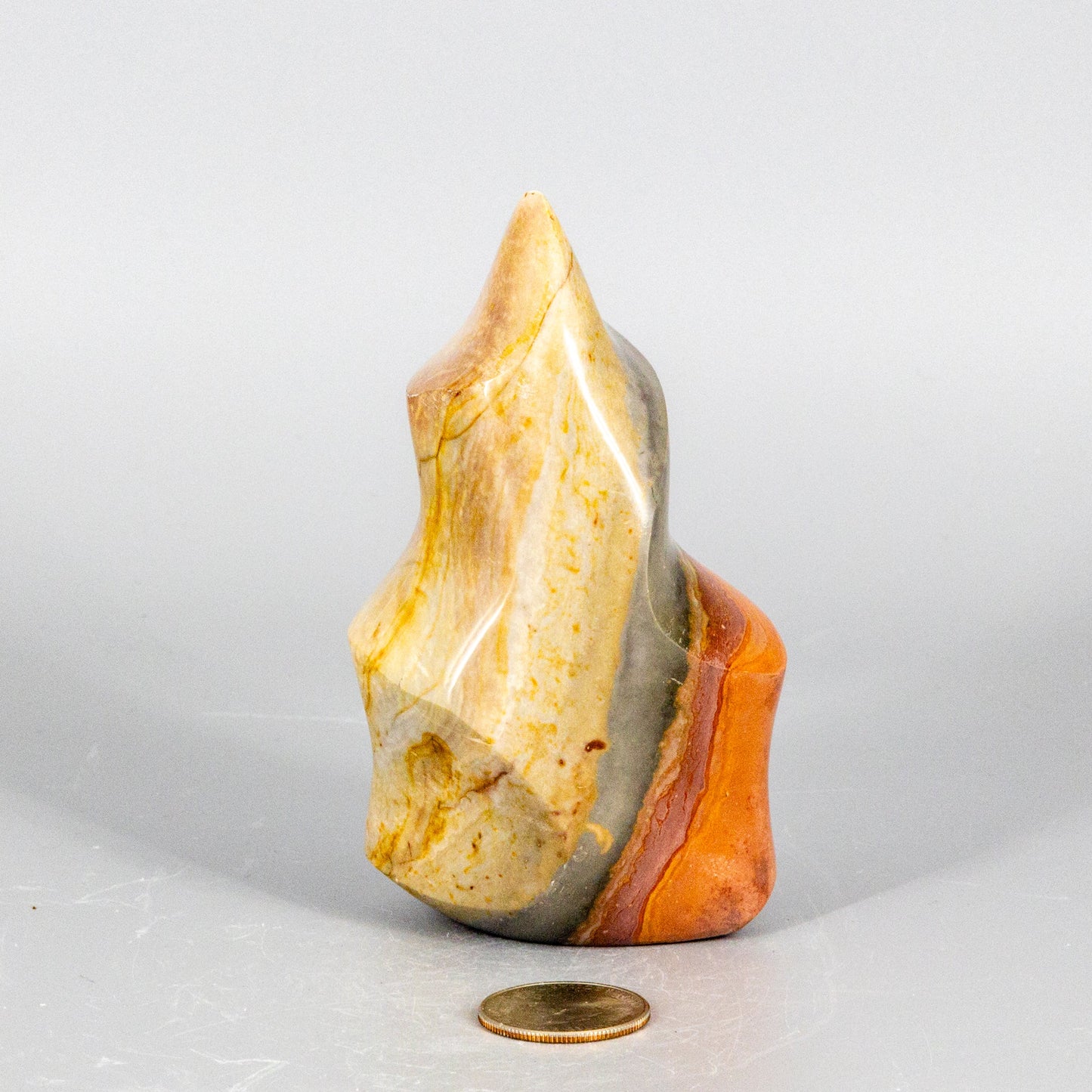 Decorative polychrome jasper flame stone with multicolored layers on a white background