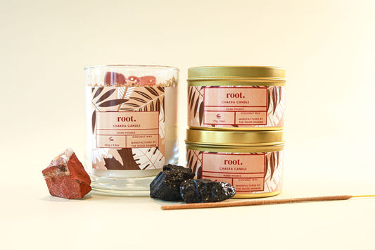 Root chakra candles with decorative elements on a light background