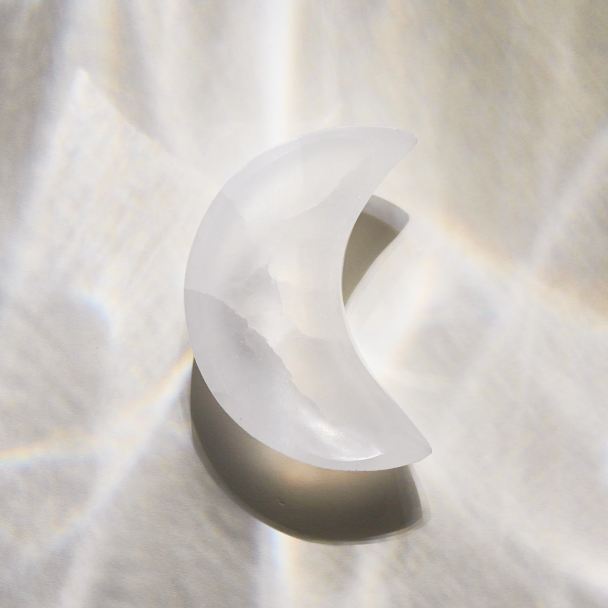 Selenite moon bowl on a neutral background