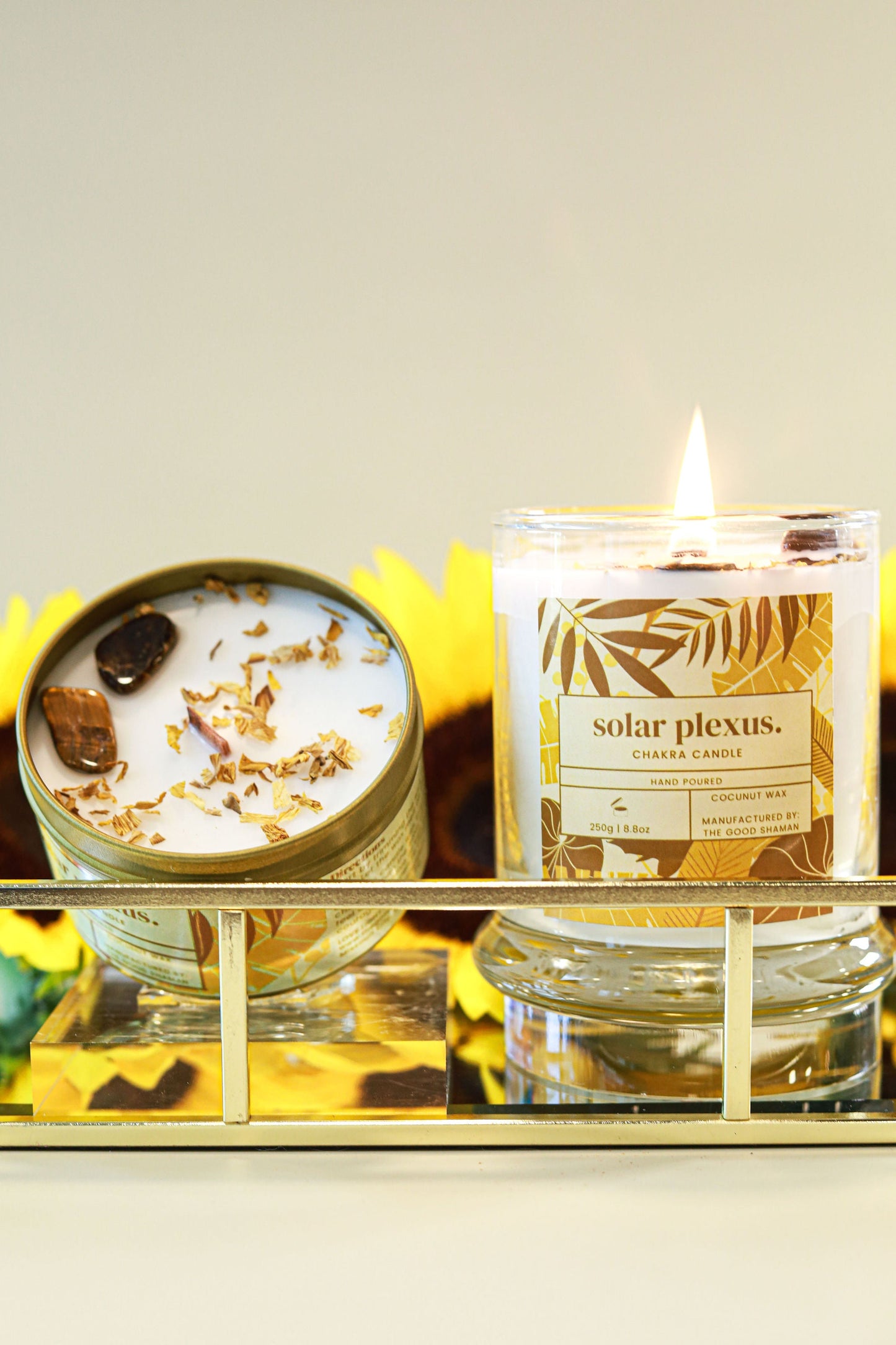 Two solar plexus candles on a decorative tray with a neutral background