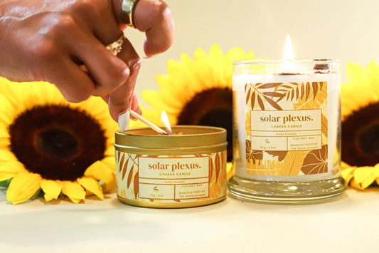 Person lighting a candle with sunflowers in the background, featuring 'solar plexus' branding.