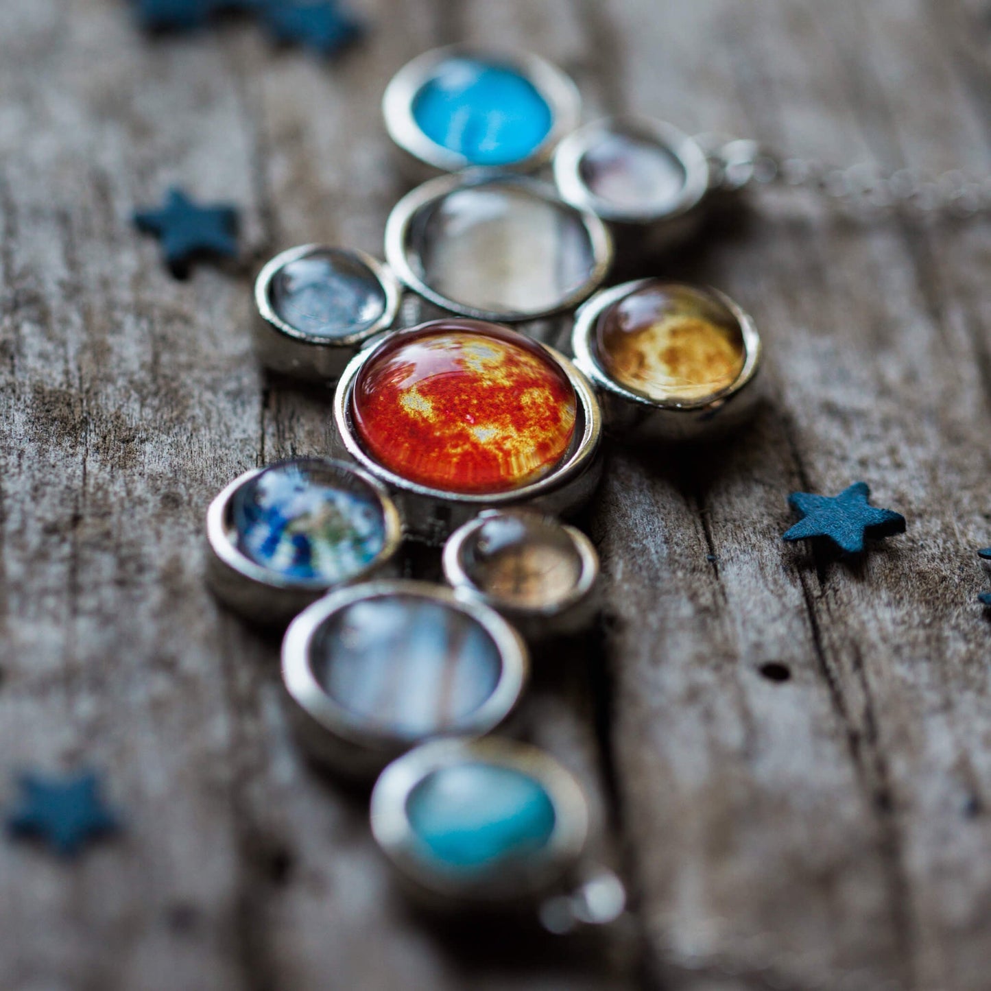 Solar system model on a wooden surface with star decorations