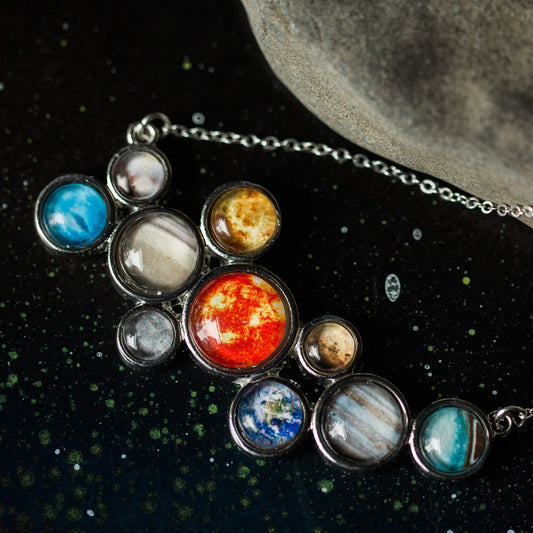 Necklace with solar system planet pendants on a dark space-themed background