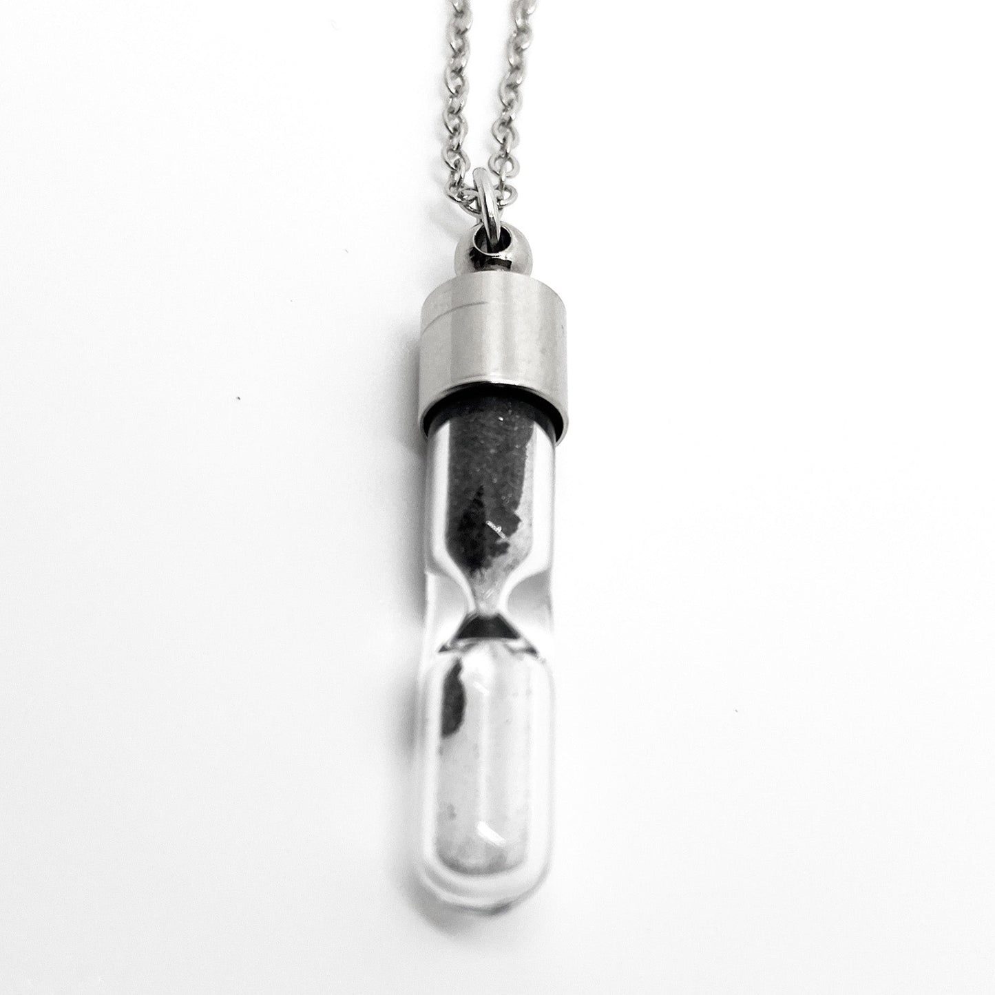 Silver hourglass-shaped pendant on a white background