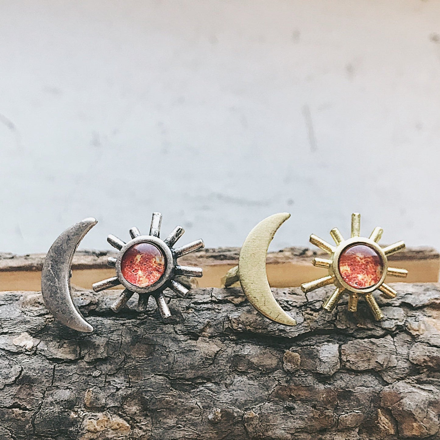 Pair of sun and moon rings on a wooden surface with a neutral background