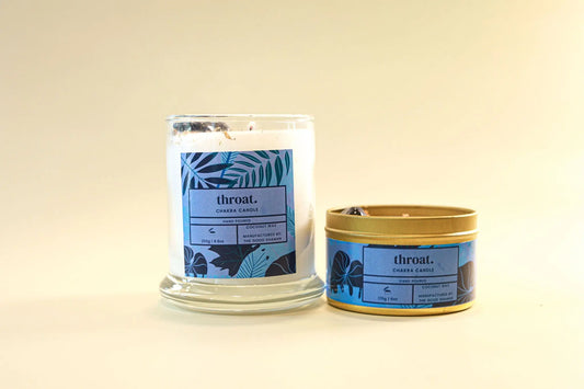 Two throat chakra candles with labels on a beige background