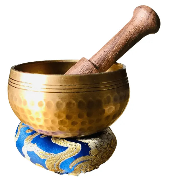 Bronze singing bowl with wooden handle on a decorative stand