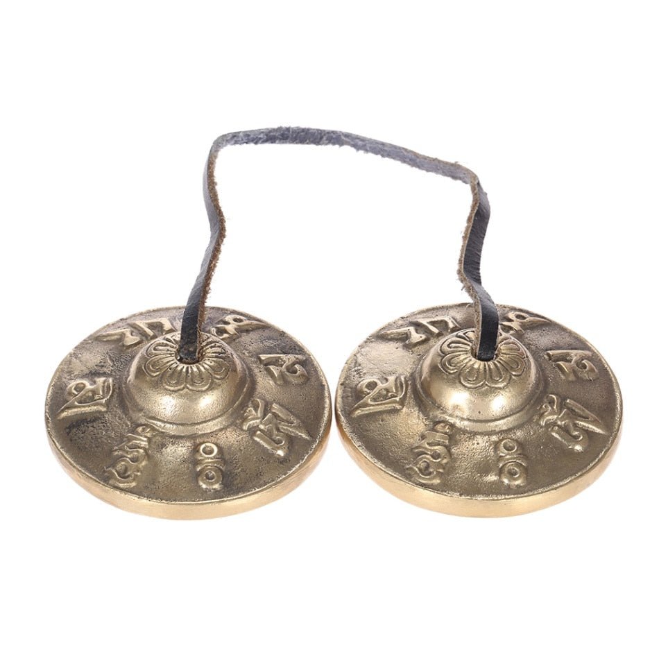 Pair of bronze hand chimes on a white background