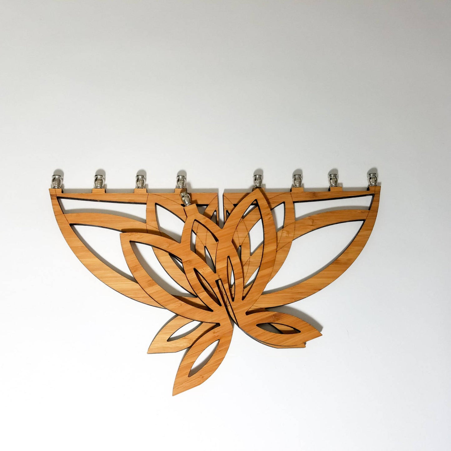 Wooden menorah with lotus flower design on a white background