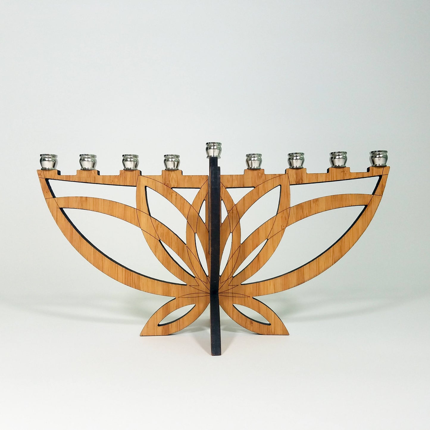 Wooden menorah with a black central stem on a white background