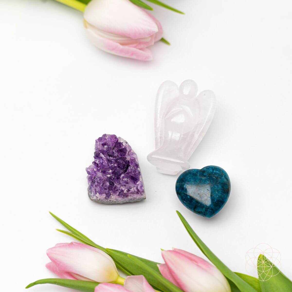 Crystal heart and amethyst with pink tulips on a white background