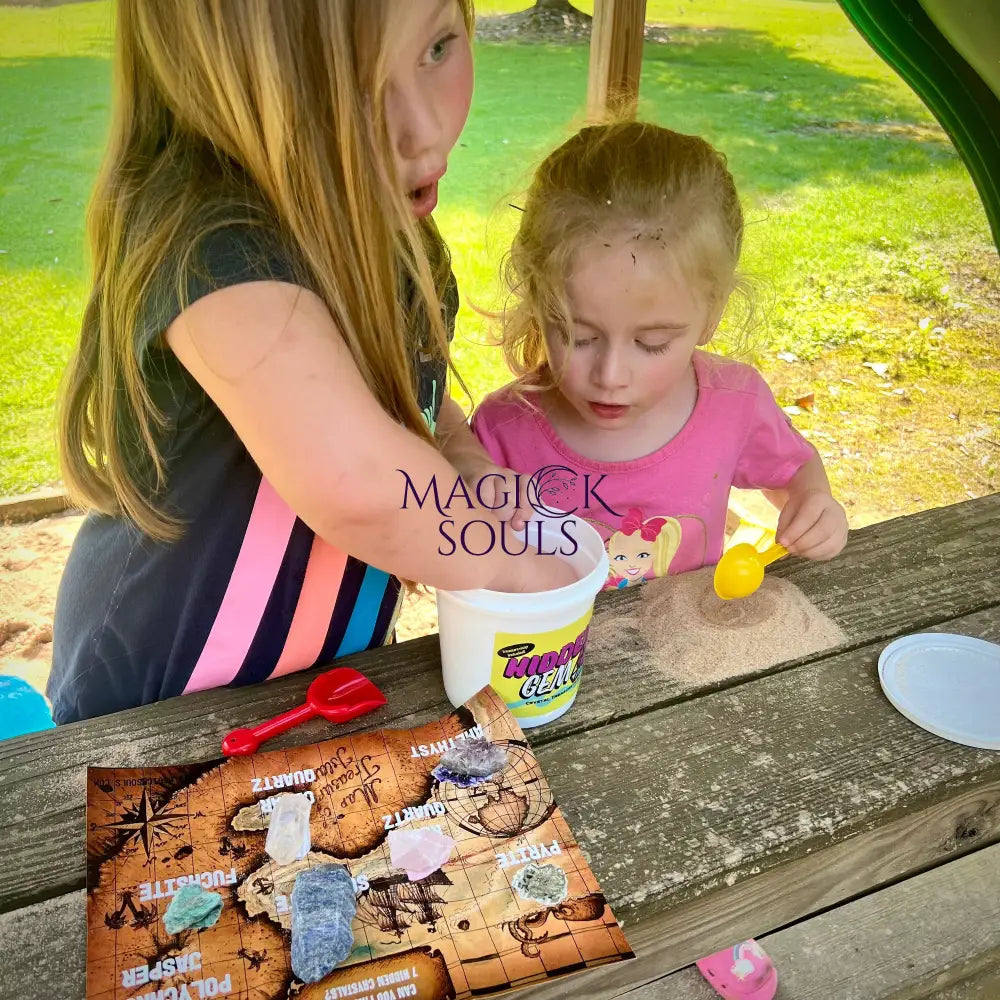 Two children playing with a hidden gem crystal dig kit on a wooden table outdoors.