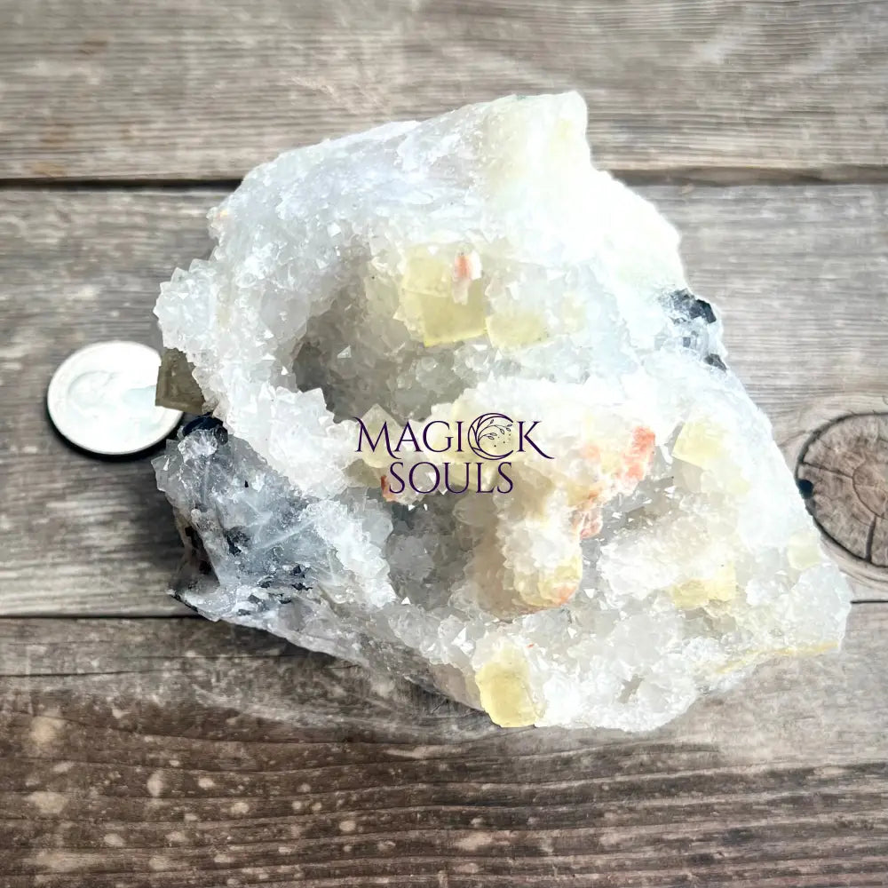 Large yellow fluorite crystal geode on a wooden surface.