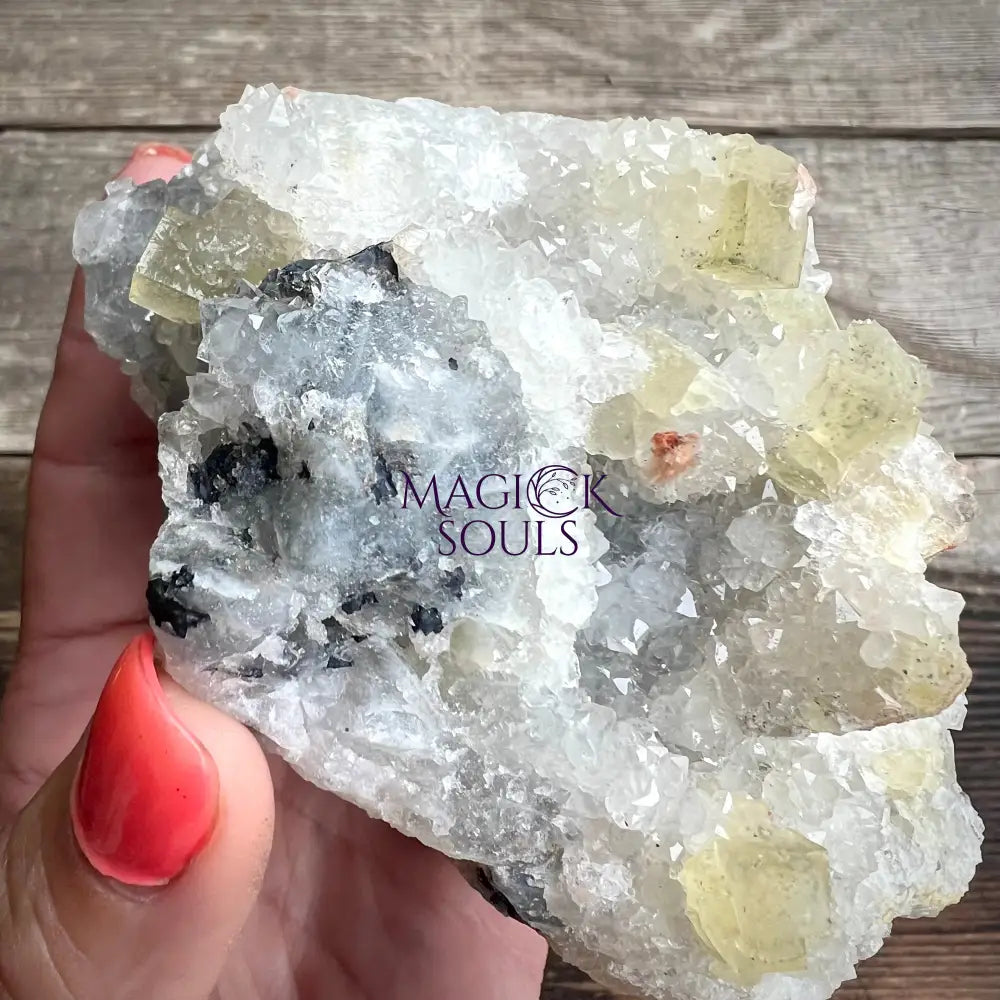 Fluorite crystal rock held by a hand.