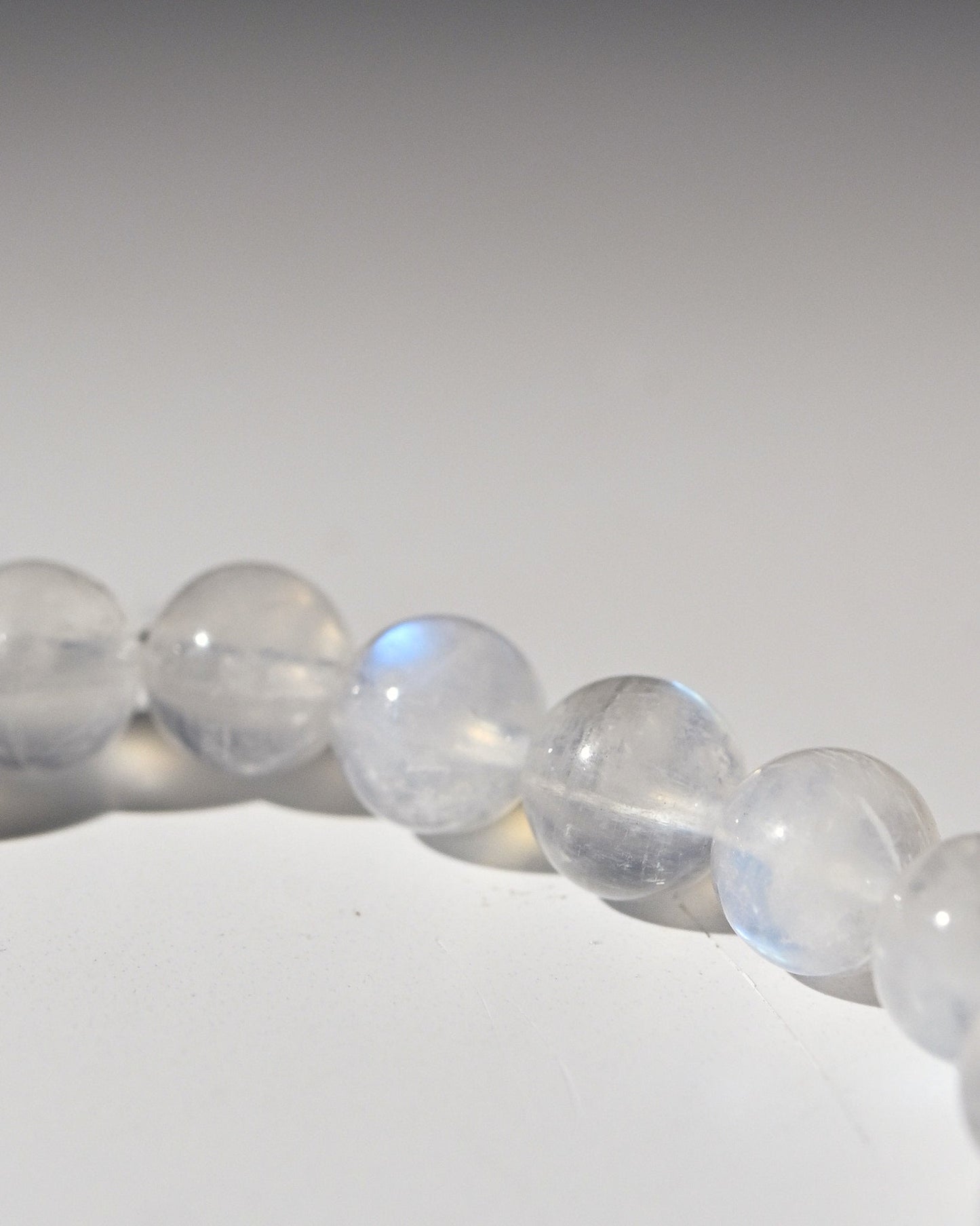 Close-up of a bracelet with rainbow moonstone beads on a white background