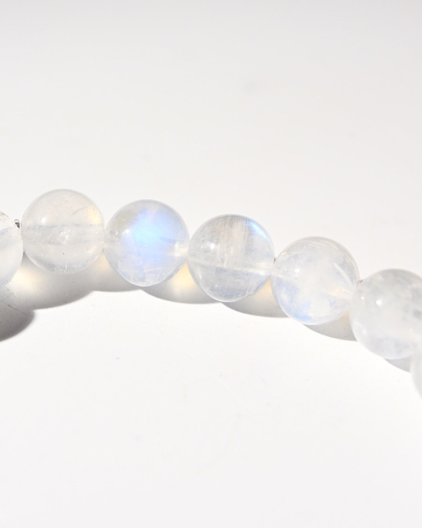 Close-up of rainbow moonstone beads on a white background